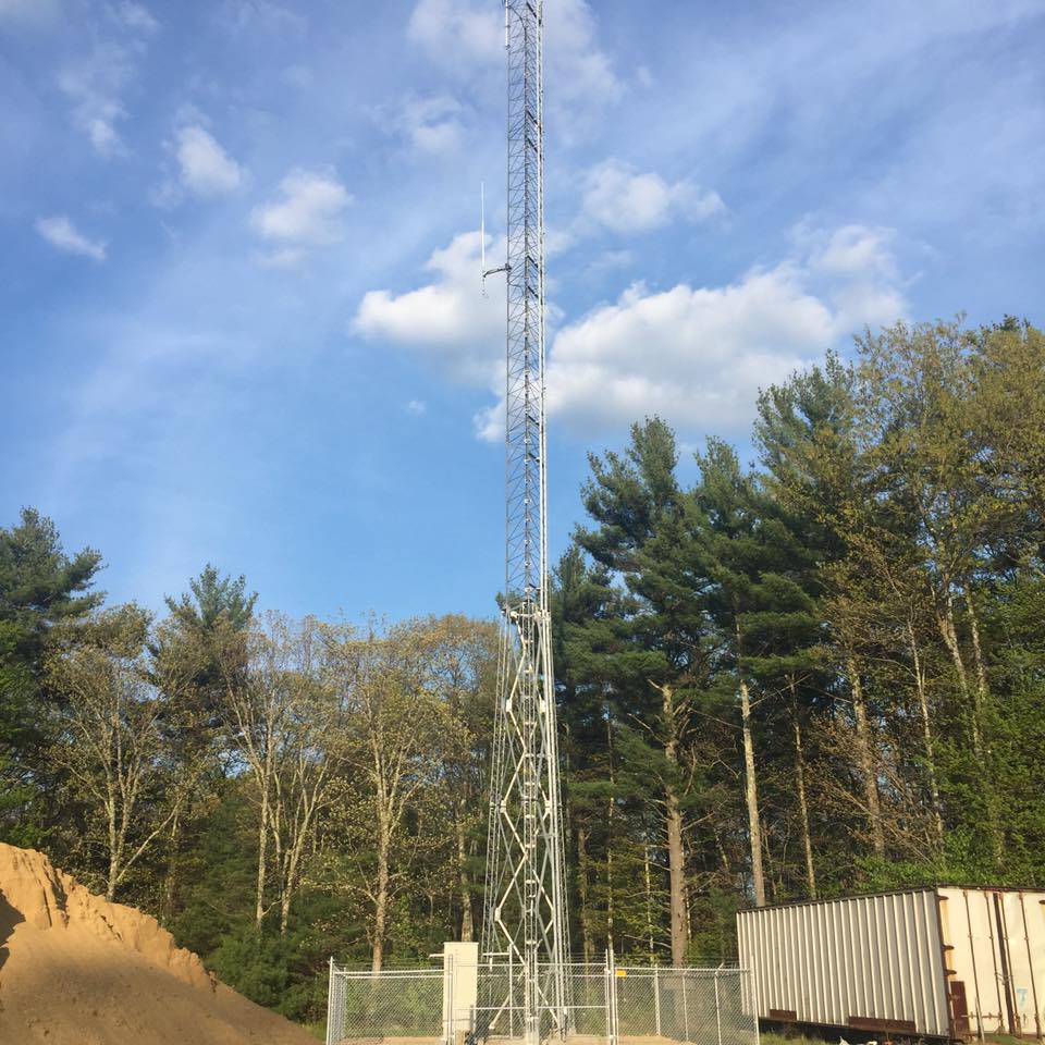 a radio tower surrounded by trees at dusk