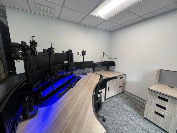 a side view of a computer desk with many monitor stands